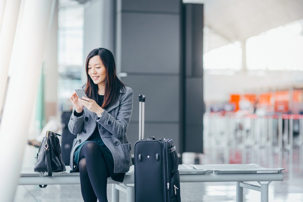 Woman using mobile phone in airport smart codes program
