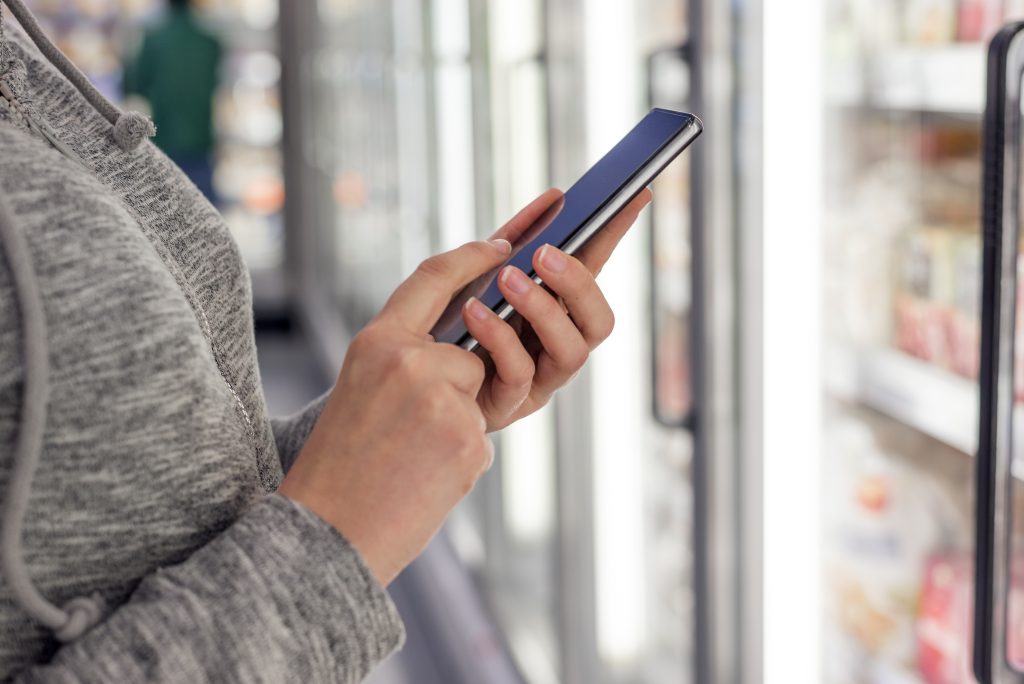 Woman checks a promotional text for savings on her mobile phone