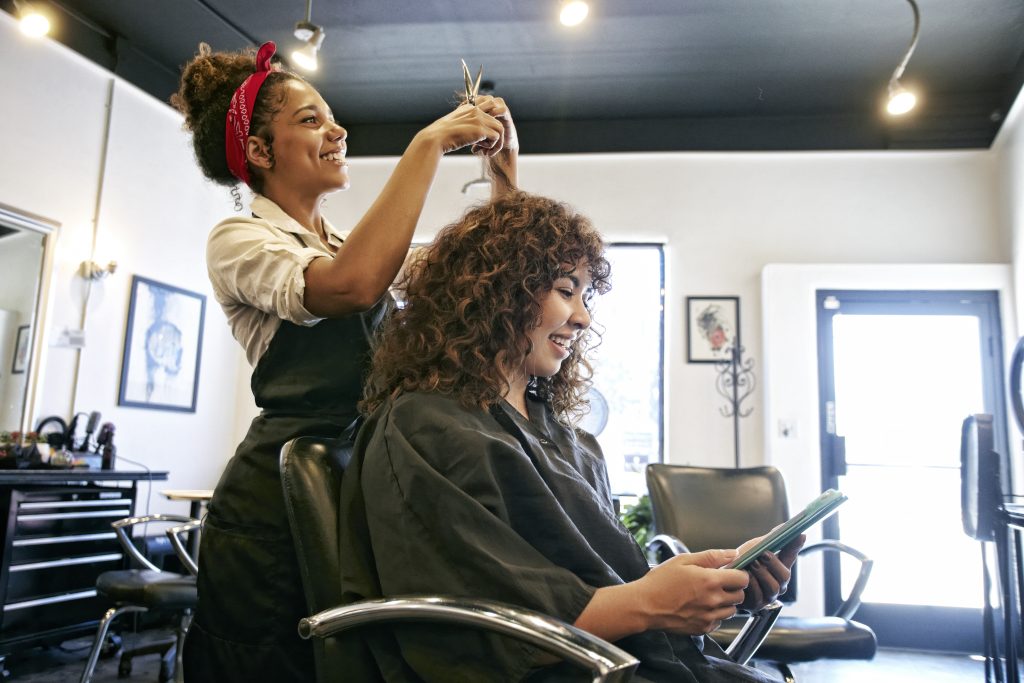 A woman getting her hair done at an appointment she made using the salon's short code scheduler