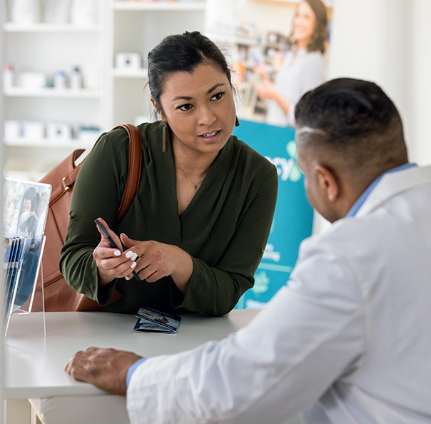 Woman using mobile phone at pharmacy for pick up short codes program